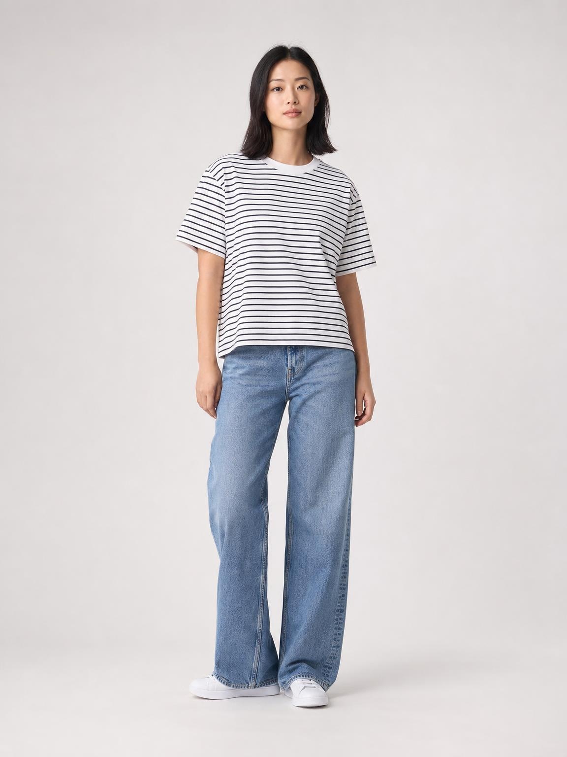 Model in striped tee and jeans on a studio cyclorama